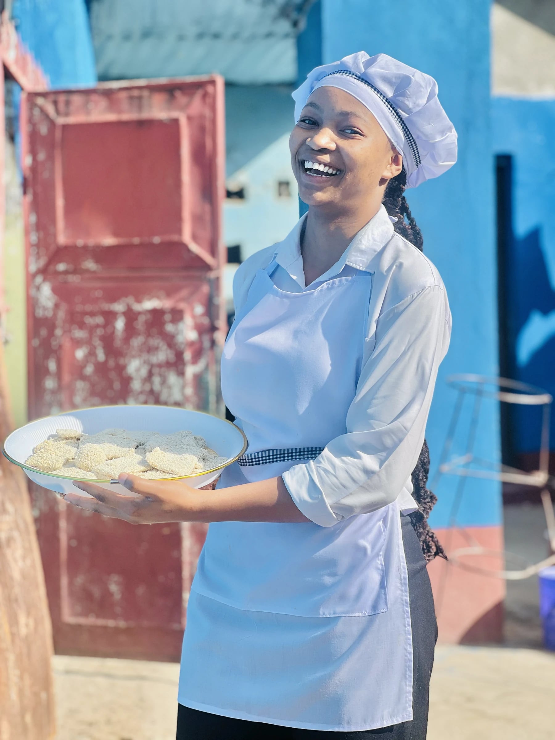 A Keepsake culinary student smiling with a plate of cake pieces outdoors