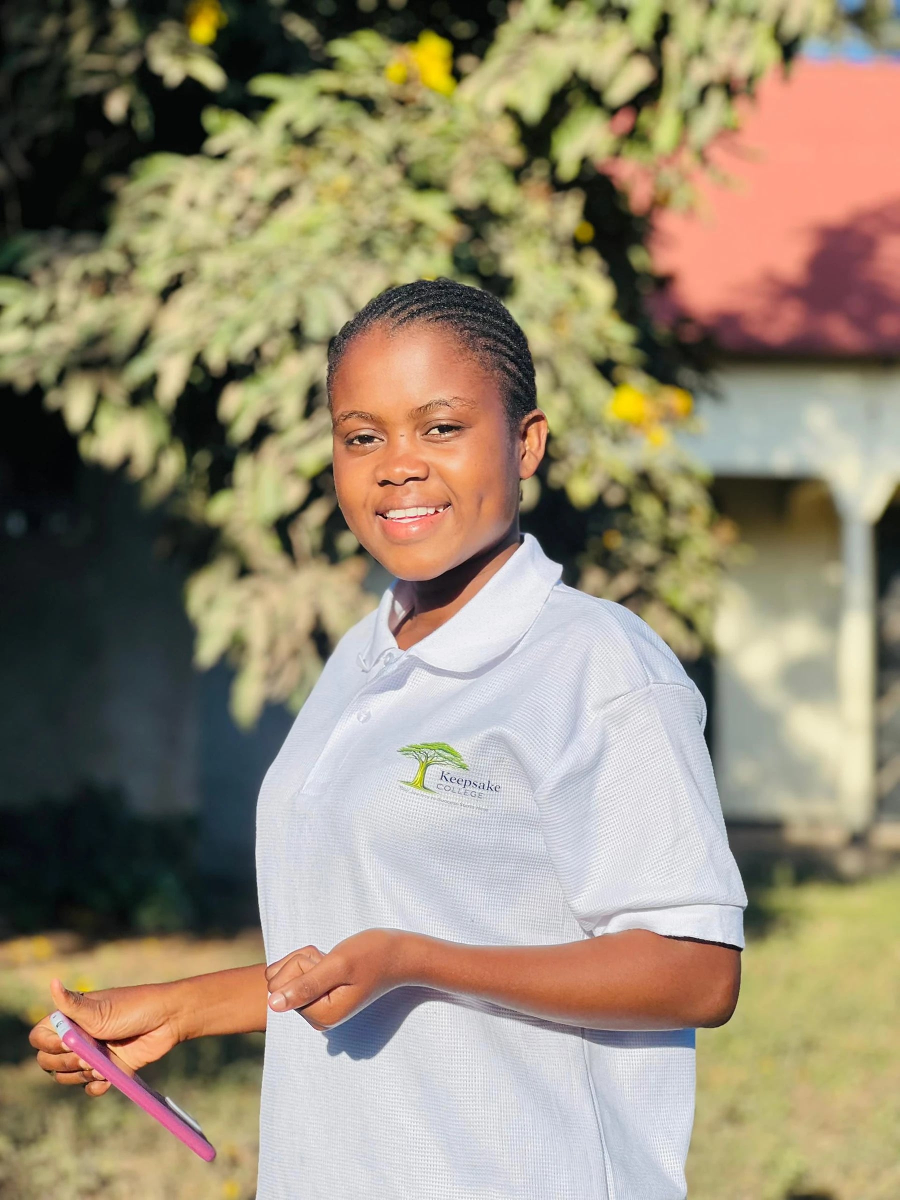 A Keepsake student standing outdoors with a phone in her hand