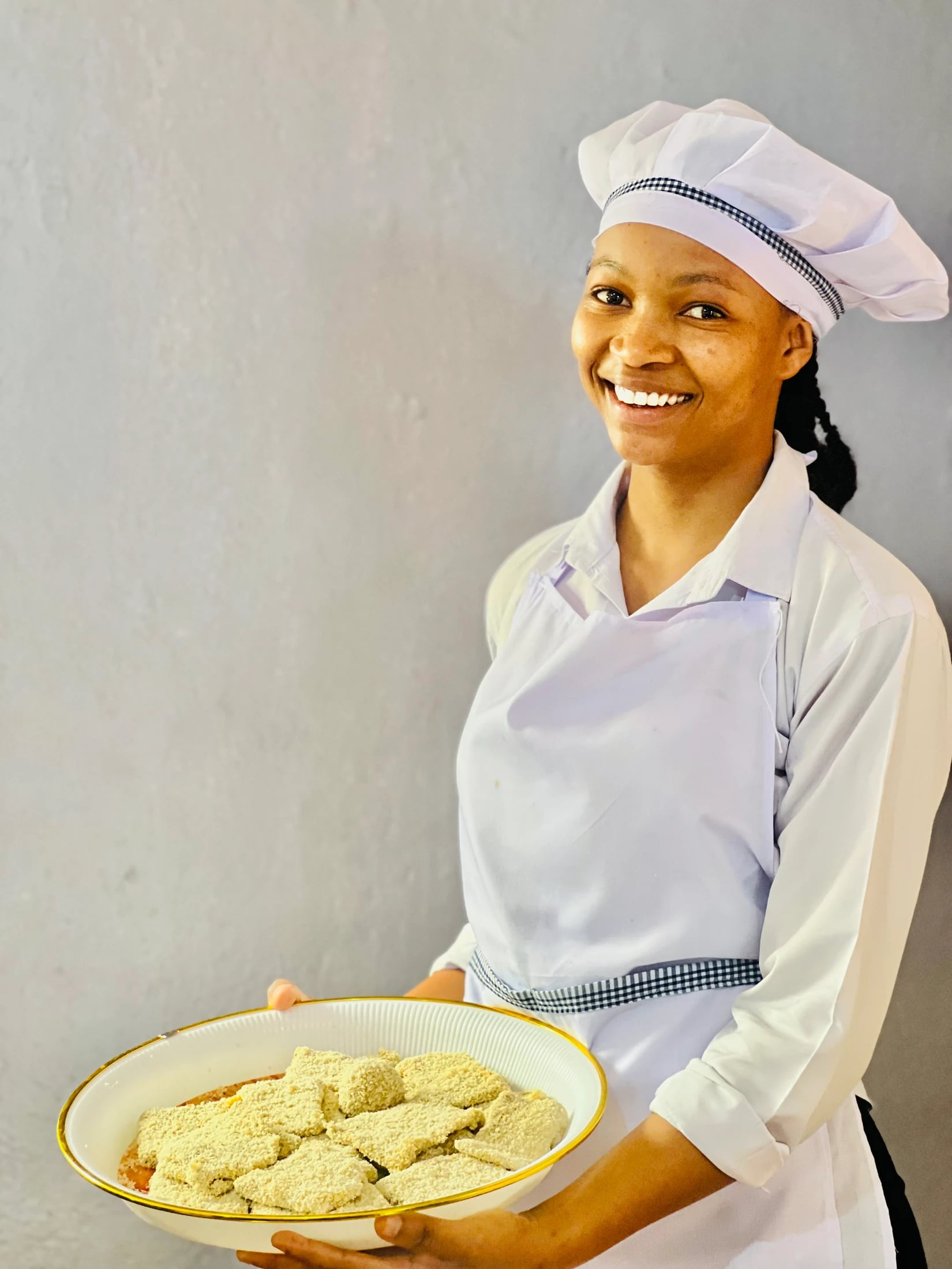 Keepsake culinary student holding a plate of baked food